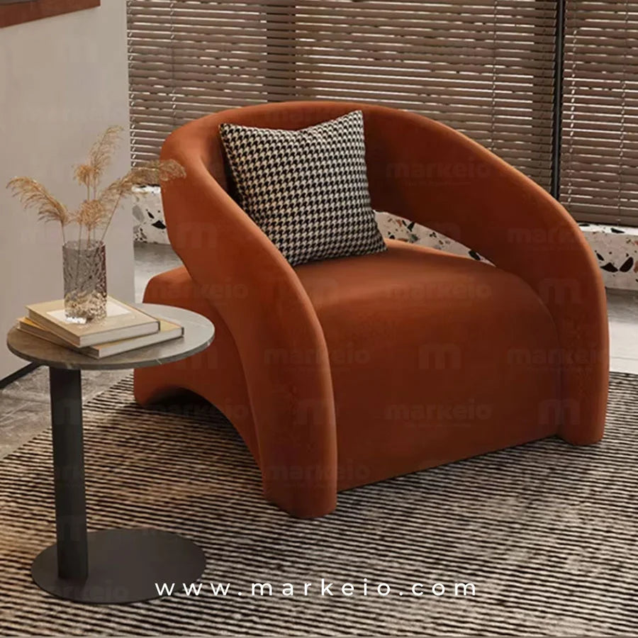Fauteuil design en tissu couleur terracotta sans repose-pieds.