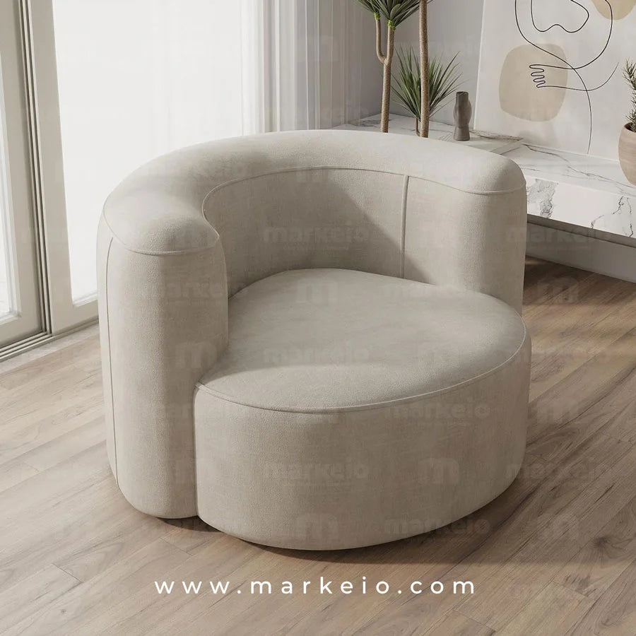 Fauteuil Ello en tissu clair associé à une table basse et des plantes d'intérieur