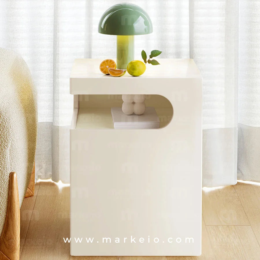 Meuble de nuit sculptural avec compartiment pour livres et accessoires.