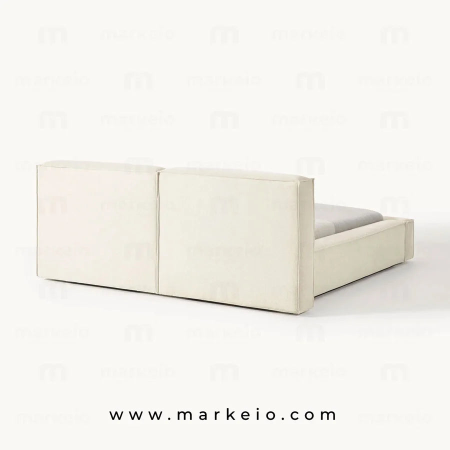 Lit Divano avec parure de lit élégante et éclairage tamisé.