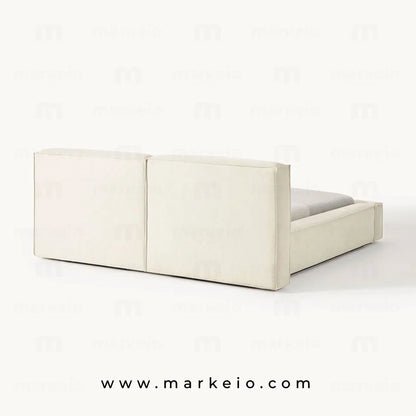 Lit Divano avec parure de lit élégante et éclairage tamisé.