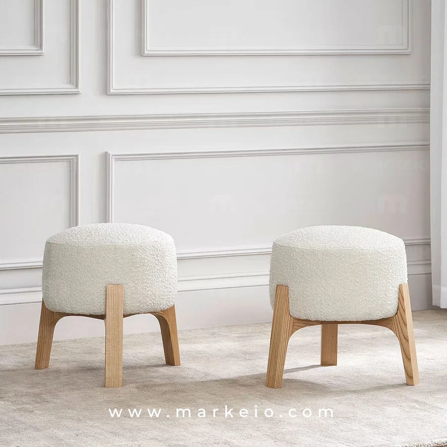 Tabouret bas en bouclette blanche avec pieds en bois massif robuste.