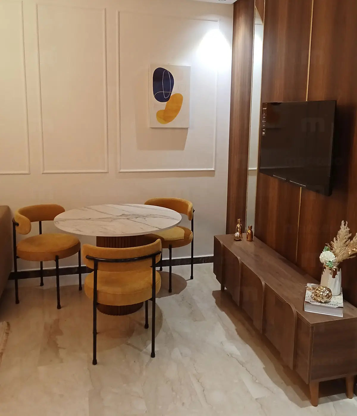 Coin repas dans un studio à Mohammedia avec une table en noyer et 3 chaises design Markeio.